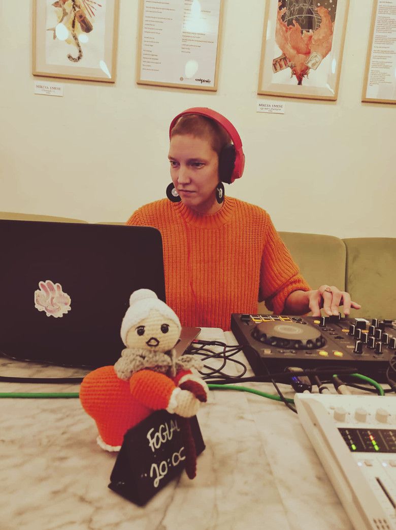 Luca Aza in an orange sweater playing a live set with a DJ controller at Három Holló, Budapest