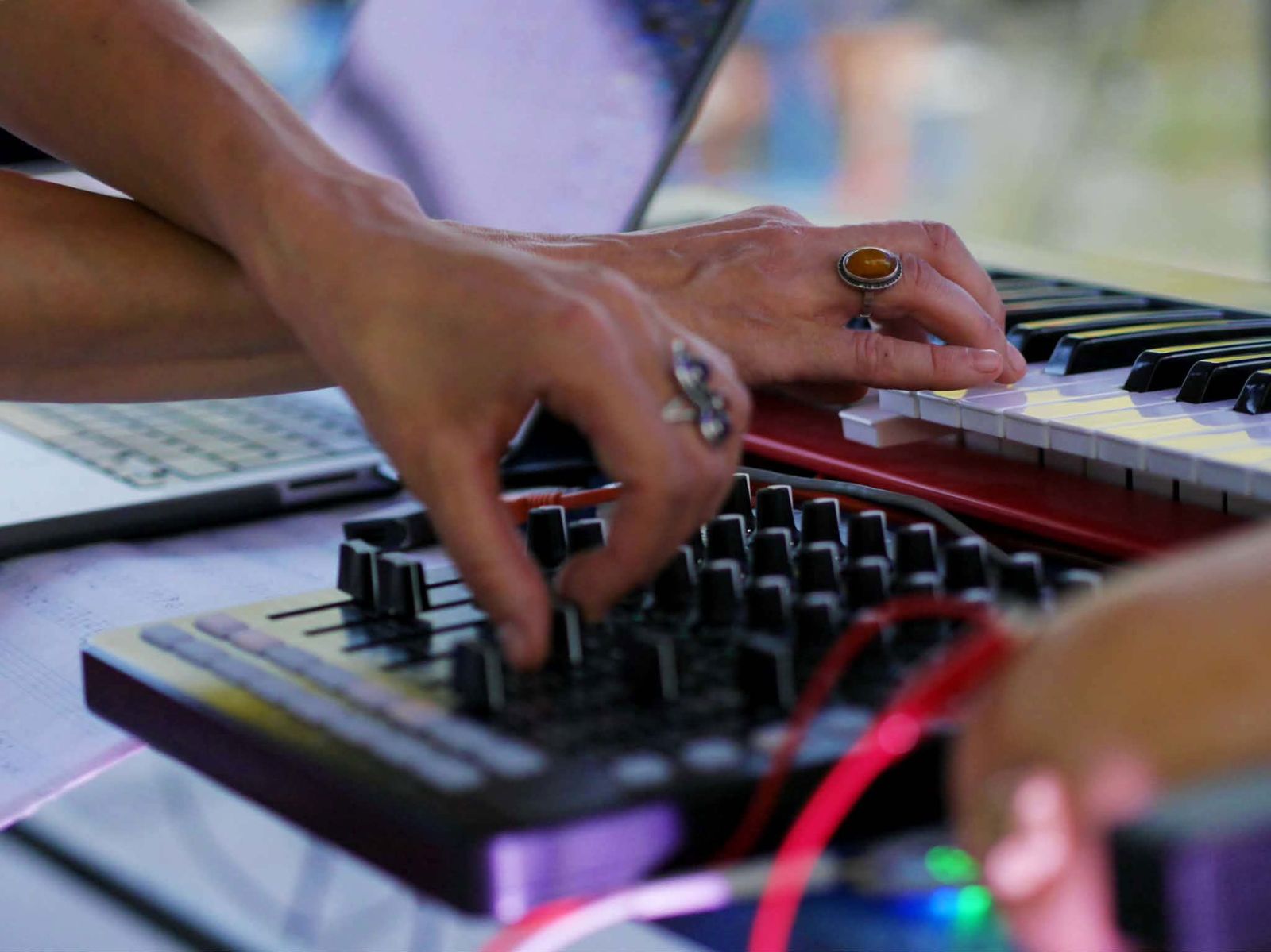 Close-up of Luca Aza's hands on a MIDI controller and red keyboard during a live ambient set at Kacsakő